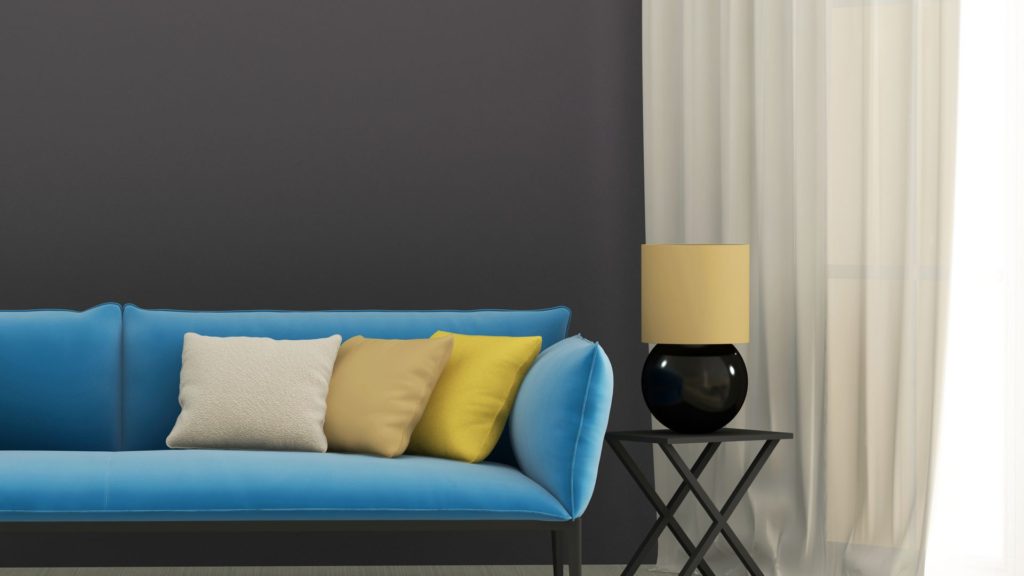 A blue couch with pillows and a table